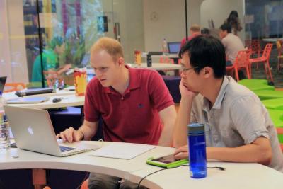 ADSC researchers William Temple and Binbin Chen work on &quot;Efficionado,&quot; their web application to encourage energy efficiency in Singapore's residential sector during the E3 Hackathon.
